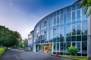 a large building with glass windows on a street at Quality Hotel Lippstadt in Lippstadt