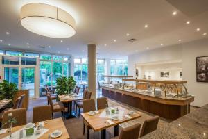 a restaurant with tables and chairs and a bar at Quality Hotel Lippstadt in Lippstadt
