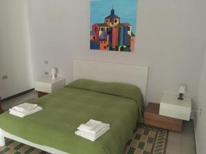sypialnia z zielonym łóżkiem i obrazem na ścianie w obiekcie Casa Vacanze Pizzicantò w mieście Irsina