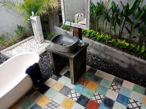 a bathroom with a sink on a tiled floor at Ubud Sawah Scenery Villa and Homestay in Tegalalang