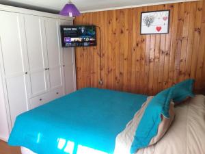 - une chambre avec un lit et une couverture bleue dans l'établissement Casa en Santiago equipada, à Santiago