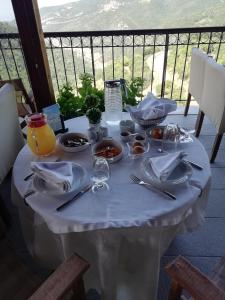 a white table with food on it on a balcony at Hotel Metoxi in Spiliá