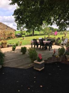 een patio met een tafel en stoelen in een tuin bij Entre Lot et Dordogne in Saint-Cirq-Madelon