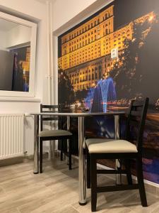 una mesa de comedor con sillas y una pintura en la pared en Apartament Cristina, en Bucarest