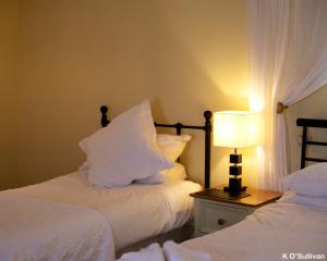 a hotel room with two beds and a lamp at The New Inn in Crediton