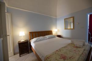 モノーポリにあるDimora del Murattianoのベッドルーム(ベッド1台、ランプ、鏡付)