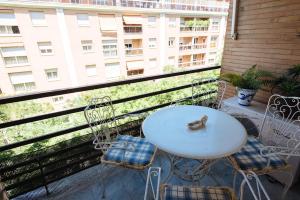 een tafel en stoelen op een balkon met een gebouw bij luminoso piso nervion in Sevilla