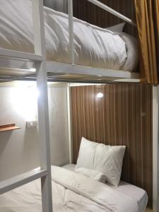 a bunk bed with white pillows in a room at Naga Hostel & Café in Thakhek