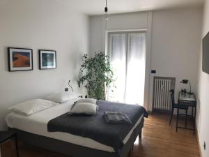 um quarto com uma cama, uma secretária e uma janela em Feel@Home Apartment+Rooms em Milão