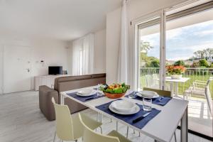 comedor y sala de estar con mesa y sillas en Venice Golf residence, en Lido de Venecia
