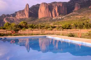 een zwembad met een berg op de achtergrond bij Camping Bungalows Armalygal in Murillo de Gállego