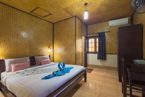 a bedroom with a bed with a blue ribbon on it at La Luna Italian Restaurant & Accommodation in Ko Lipe