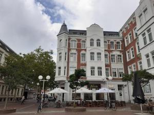 budynek ze stołami i parasolami na ulicy miejskiej w obiekcie Liberty w mieście Wilhelmshaven