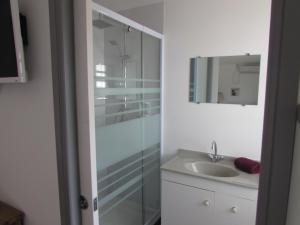 W łazience znajduje się szklana kabina prysznicowa i umywalka. w obiekcie "Tom" Chez Tom et Dilou w mieście Koumac