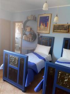 a bedroom with two beds with blue and white at Prospettiva Polignano in Polignano a Mare