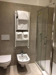 a bathroom with a toilet and a sink and a shower at Uma Apartments in Venice