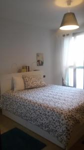 um quarto com uma cama num quarto com uma janela em wind rose em Bosa