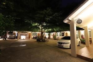 een witte auto geparkeerd naast een gebouw 's nachts bij Right Spot in Pattaya South