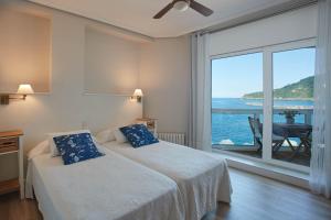 a bedroom with a bed with a view of the ocean at Pensión Itxasoa in San Sebastián