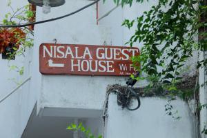 Un cartel de una casa de huéspedes Nisska en un edificio. en Nisala Guest -Galle Dutch Fort, en Galle