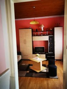 ein Wohnzimmer mit einem Tisch und einer roten Wand in der Unterkunft Apartman Luka in Sokobanja
