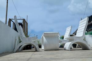 two white benches sitting next to a building at Nisala Guest in Galle