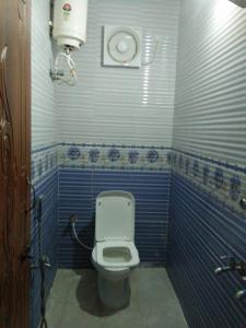 吉登伯勒姆Parisha Residency- Temple Side Hotel的浴室设有蓝色和白色瓷砖,配有卫生间