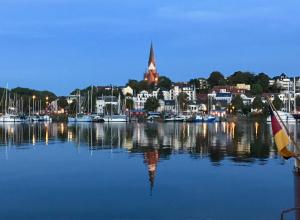 a group of boats in a harbor with a city at Ferienwohnung Alsterbogen in Flensburg