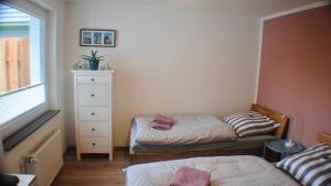 a small bedroom with two beds and a dresser at Ferienwohnung Alsterbogen in Flensburg