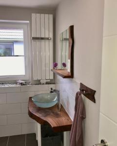 a bathroom with a bowl sink and a mirror at Ferienwohnung Alsterbogen in Flensburg