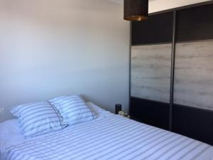 a bedroom with a bed with blue and white pillows at Villa avec piscine privée, vue sur mer et plage à pied 800m in Saint-Jean-de-Luz +22 photos