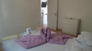 a room with a bed with purple blankets and a dresser at Villa Vera in Hvar