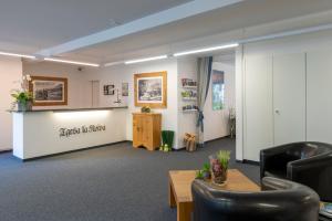 - une salle d'attente avec des chaises et une table dans l'établissement Apartment Tgesa La Roiva mit Hallenbad und Sauna, à Lenzerheide