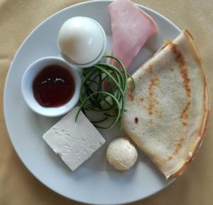 een bord eten met een broodje en vlees en saus bij Hotel Continental in Kiten