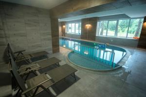 uma piscina interior com bancos e cadeiras em 4family *RESORT*SPA* em Szklarska Poręba