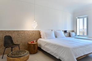 Un dormitorio con una cama, una silla y una ventana en Arota Exclusive Villas, en Akrotiri