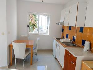 a small kitchen with a table and a table and chairs at Luka 3 in Podgora