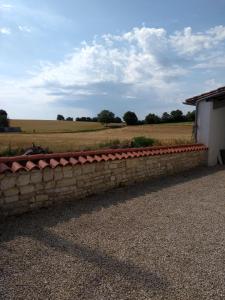 eine Backsteinmauer mit einem Feld im Hintergrund in der Unterkunft La maisonnette in Les Adjots