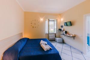 Un dormitorio con una cama azul y un reloj en la pared en Peppa Room en Ravello