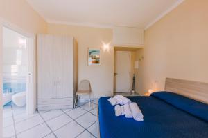 a bedroom with a blue bed with towels on it at Peppa Room in Ravello