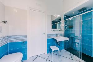 a blue bathroom with a toilet and a sink at Peppa Room in Ravello