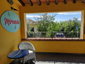 a patio with a table and a chair and a window at Locanda Miranda in Tellaro