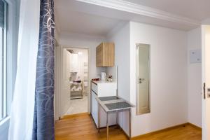 een keuken met witte muren en een tafel in een kamer bij City Apartment an der Caracalla Therme in Baden-Baden