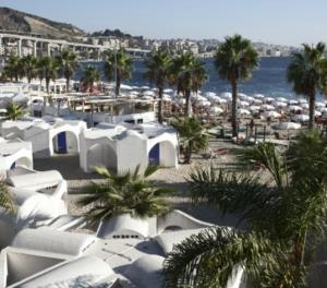 - une plage avec des tentes blanches, des palmiers et l'eau dans l'établissement Bed and breakfast lagiocosa, à Reggio de Calabre