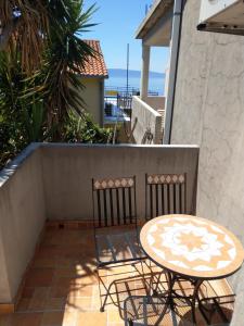 a patio with a table and chairs on a balcony at Luka 3 in Podgora