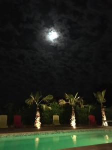 Una luna llena sobre una piscina por la noche. en Les cigales des prés Studio, en Aups