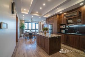 a kitchen with wooden cabinets and a table with chairs at Irest Apartment in Hanoi