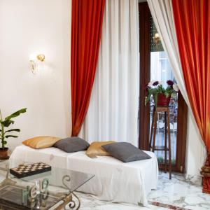 ナポリにあるArtis Domusのベッド2台、赤いカーテン付きの窓が備わる客室です。
