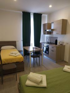 a room with two beds and a table and a kitchen at Naxos Laguna Beach in Giardini Naxos
