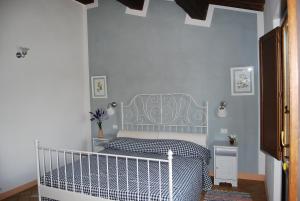 a bedroom with a bed with a blue wall at La Casa Di Piandelbello in San Venanzo